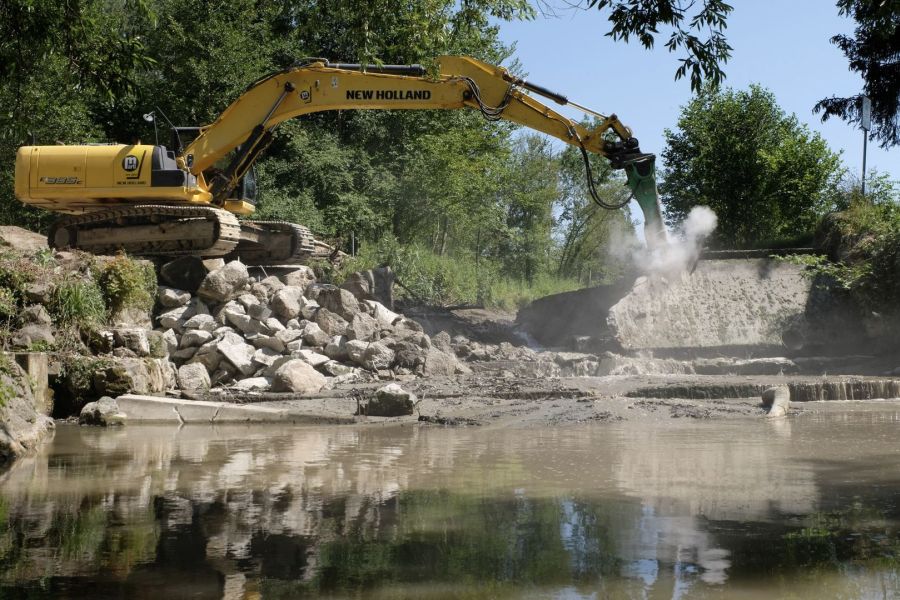Bagger entfernt altes Wehr im Fluss